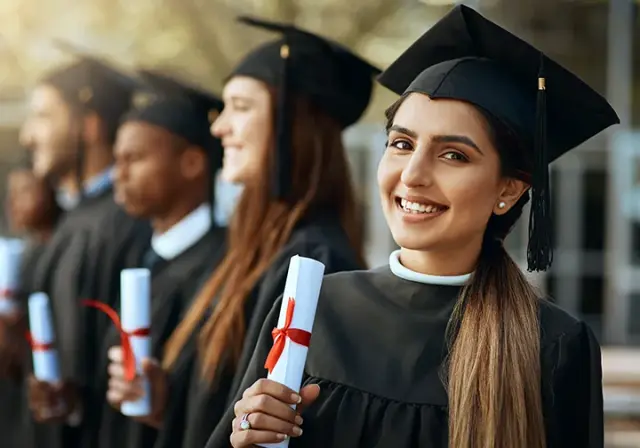 Graduating students smiling in caps and gowns